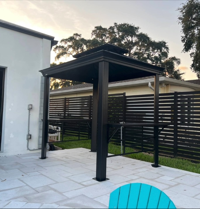 Black metal gazebo assembled on backyard patio — Quality Handyman Services Tampa